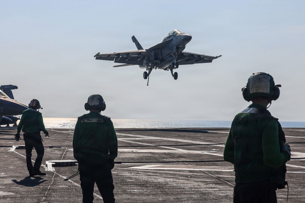 Photo by HANNAH TROSS / US NAVY / AFP  In this handout photograph released by the US Navy on February 6, 2026, an F/A-18F Super Hornet, attached to Strike Fighter Squadron (VFA) 41, makes an arrested landing on the flight deck of Nimitz-class aircraft carrier USS Abraham Lincoln in the Arabian Sea on January 30, 2026.