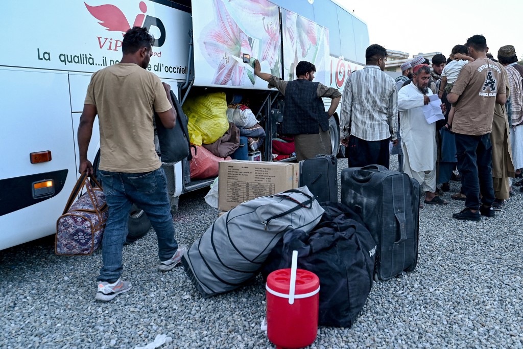 fghan refugees deported from Iran, wait to board a bus at a makeshift camp in Kabul on July 16, 2025. Three million Afghans could return to their country this year, a UN refugee official said July 11, warning that the repatriation flow is placing intense pressure on an already major humanitarian crisis. (Photo by Wakil KOHSAR / AFP)