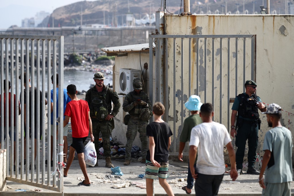 Migrants cross the Ceuta-Morocco border gate in the Spanish North African enclave of Ceuta on August 1, 2026. (AFP)