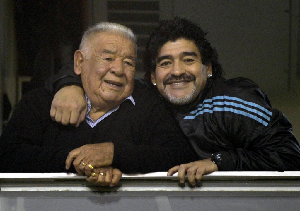 Photo by JUAN MABROMATA / AFP  Argentine former footballer and United Arab Emirates Al Wasl coach Diego Maradona (R) embraces his father "Don Diego" before the start of the Copa Libertadores 2012 first leg semifinal football match between Argentina's Boca Juniors and Universidad de Chile at "La Bombonera" stadium in Buenos Aires, Argentina, on June 14, 2012.