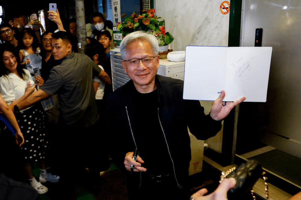 Nvidia's (NVDA.O) CEO Jensen Huang interacts with the media and supporters outside a restaurant in Taipei, Taiwan May 16, 2025. REUTERS/Ann Wang