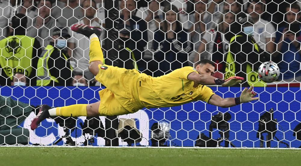 Italy's goalkeeper Gianluigi Donnarumma makes a save against England's Jadon Sancho during penalty shootout of the Euro 2020 soccer championship final match between England and Italy at Wembley Stadium in London, Sunday, July 11, 2021.