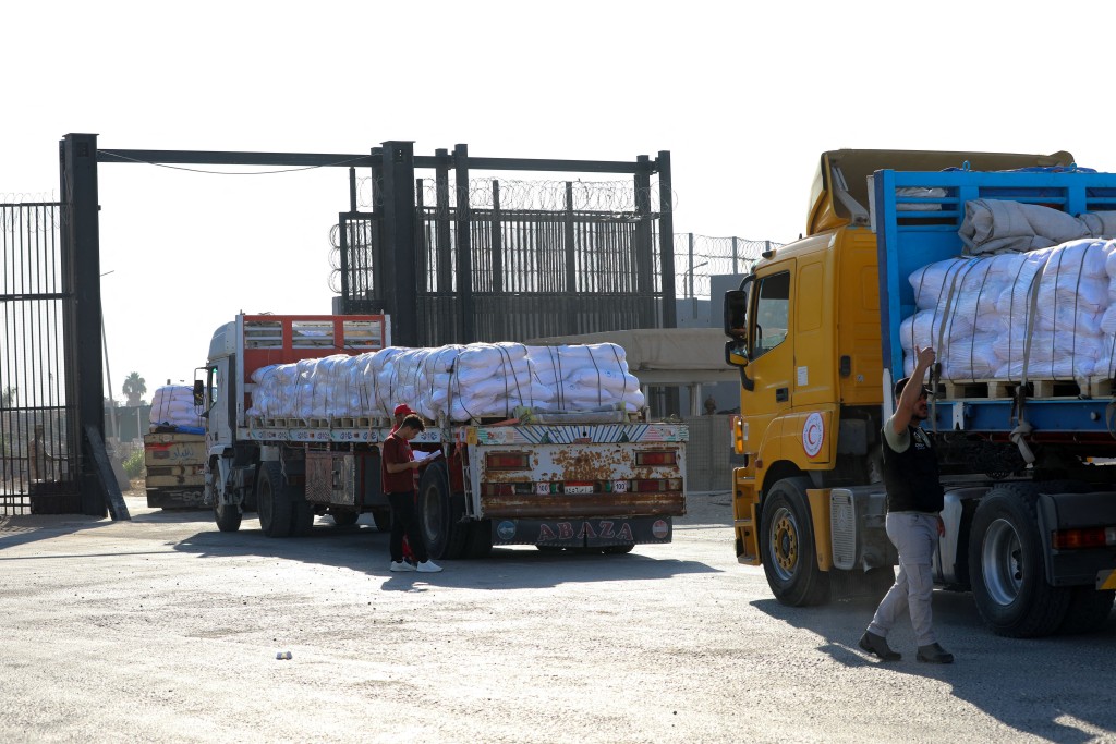 Trucks loaded with humanitarian aid drive toward the Gaza Strip through the Egyptian side of the Rafah crossing on July 27, 2025. (AFP)