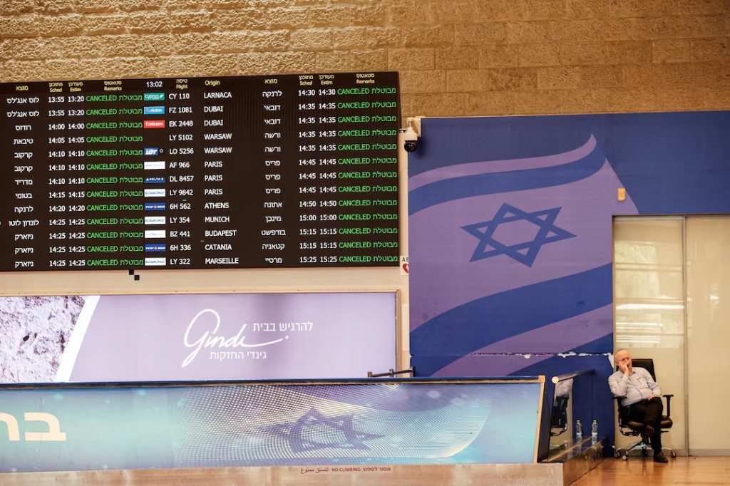 A staff of Ben Gurion International Airport, sits at the arrivals terminal as all flights from and to the airport are indicated cancel, following an overnight Israeli attack on Iran, in Lod near Tel Aviv, Israel June 13, 2025 REUTERS/Tomer Appelbaum