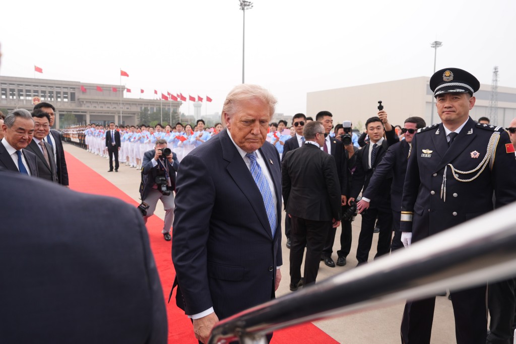 President Donald Trump boards Air Force One, Friday, May 15, 2026, at Beijing Capital International Airport in Beijing. On the left is China's Foreign Minister Wang Yi. (AP Photo/Mark Schiefelbein)