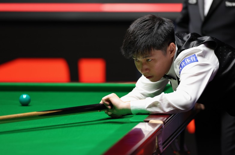 Zhao Xintong plays a shot during his semi-final match against Ronnie O'Sullivan. XINHUA