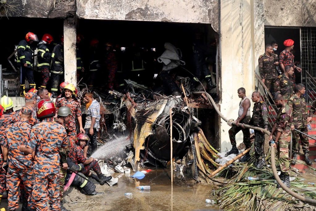 Firefighters and army members work next to the wreckage of an air force training aircraft after it crashed into Milestone College campus, in Dhaka, Bangladesh, July 21, 2025. (Reuters)