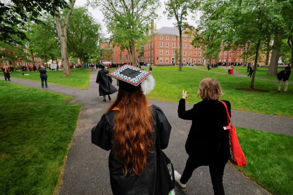 People walk to attend the 374th Commencement exercises at Harvard University in Cambridge, Massachusetts, U.S., May 29, 2025. REUTERS/Brian Snyder/File Photo