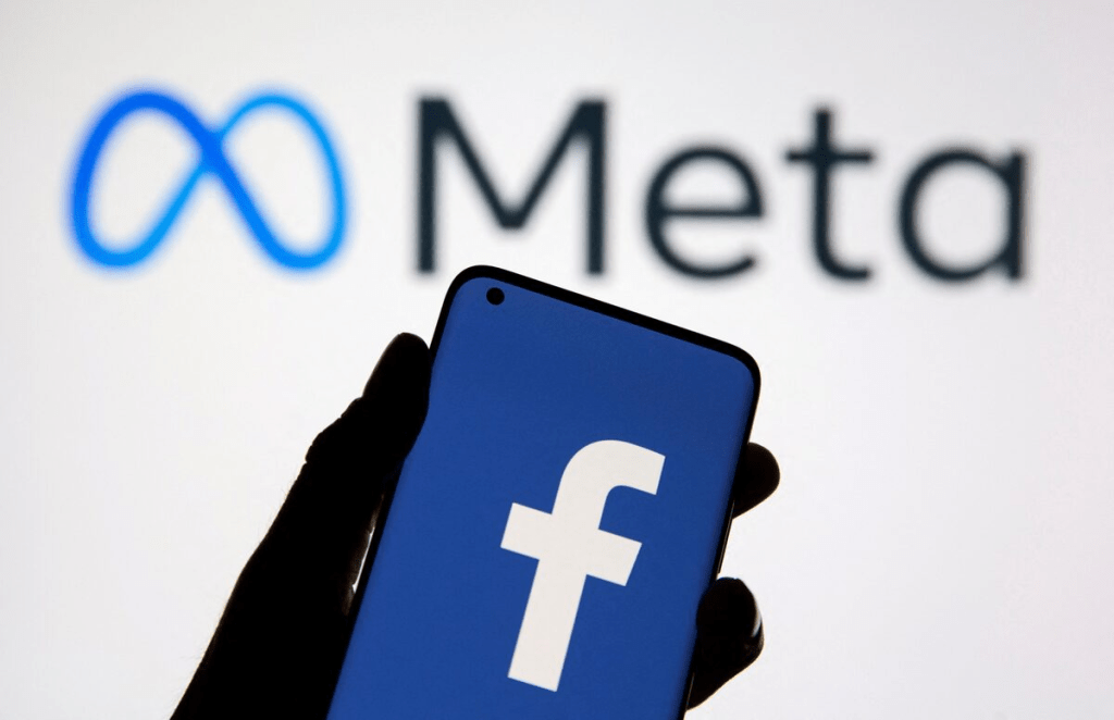 A smartphone with Facebook's logo is seen in front of displayed Facebook's new rebrand logo Meta in this illustration taken October 28, 2021. Reuters