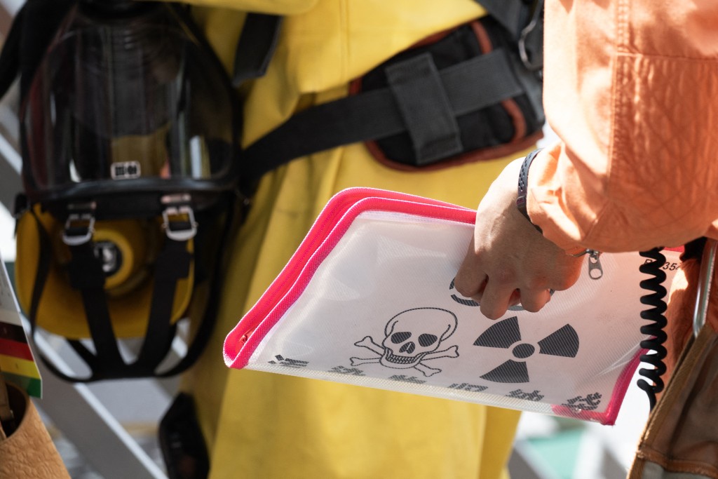 Emergency personnel hold a HAZMAT folder outside the Ginza 6 Shopping Center in Tokyo on May 25, 2026, after an individual allegedly sprayed a substance in the area. (AFP)
