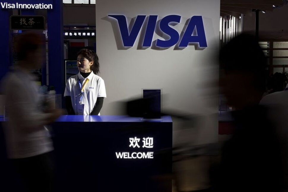 People walk past the Visa logo at its booth during the first China International Supply Chain Expo (CISCE) in Beijing, China November 28, 2023. REUTERS/Florence Lo
