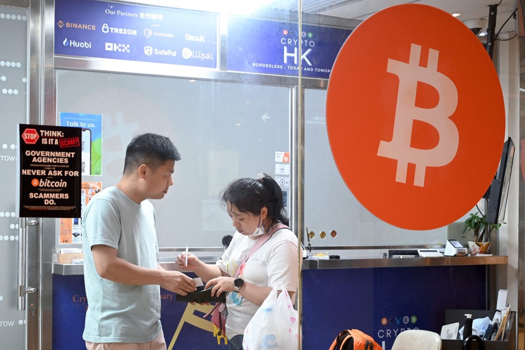 This photo taken on May 27, 2023 shows customers in a cryptocurrency exchange office in Hong Kong. Retail investors in Hong Kong may soon be able to buy popular cryptocurrencies like bitcoin at government-licensed exchanges, thanks to new rules meant to bolster the city's standing as a digital asset hub. (Photo by Peter PARKS / AFP) / TO GO WITH HongKong-China-economy-Cryptocurrency,FOCUS by Holmes CHAN