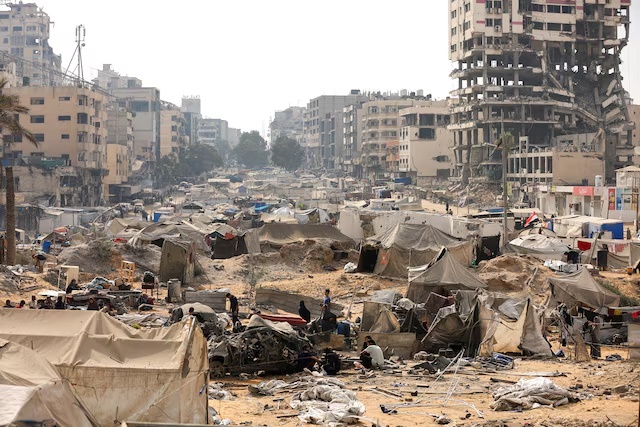 Palestinians inspect a tent camp, which was sheltering displaced people, after it was damaged in an overnight Israeli air strike on a nearby residential building, in Gaza City, September 13, 2025. REUTERS/Dawoud Abu Alkas/File Photo 