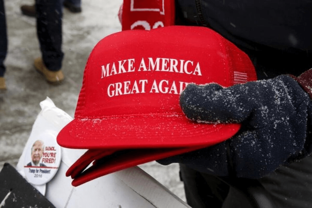 Trump campaign merchandise vendor David Dickson from Florida holds Trump campaign "Make America Great Again" hats dusted with falling snow outside a Trump campaign town hall event in Londonderry, New Hampshire February 8, 2016. REUTERS/Jim Bourg