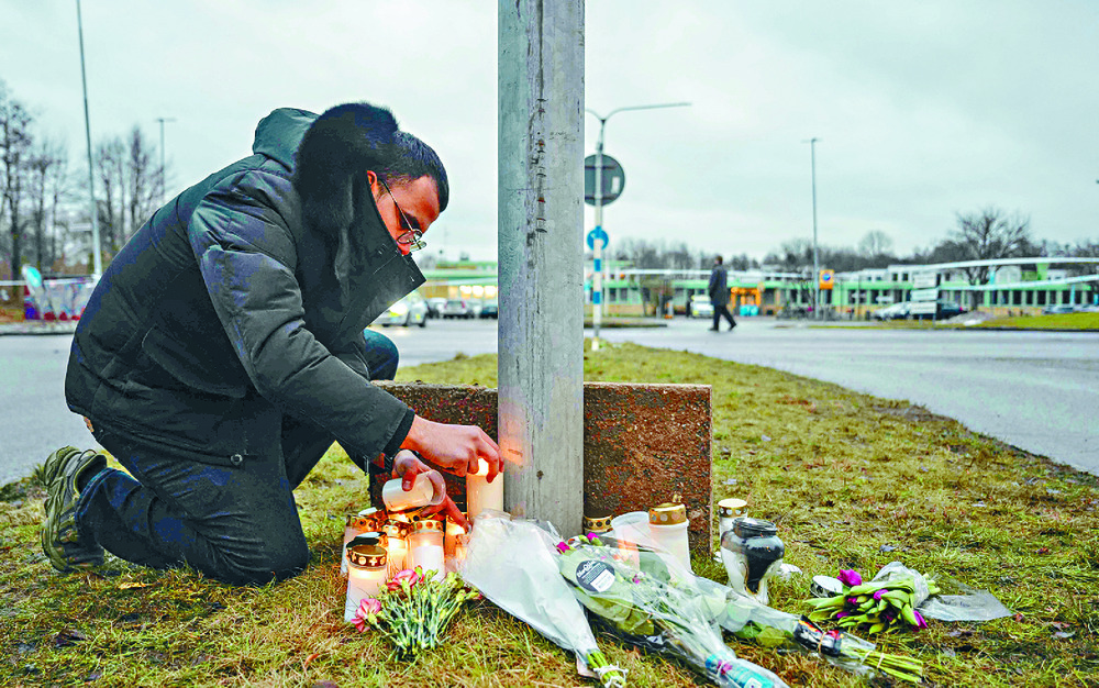 A man lights candles at a makeshift vigil in Orebro. AFP A man lights candles at a makeshift vigil in Orebro. AFP