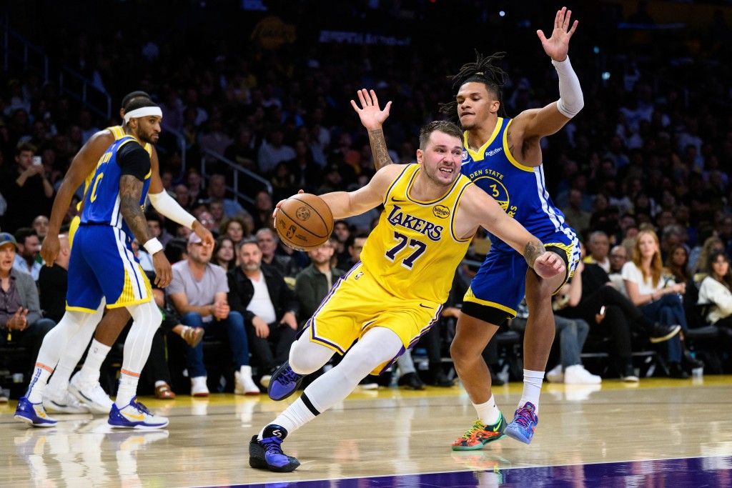 Los Angeles Lakers guard Luka Doncic (77) drives past Golden State Warriors guard Will Richard (3) during the first half. (Reuters)