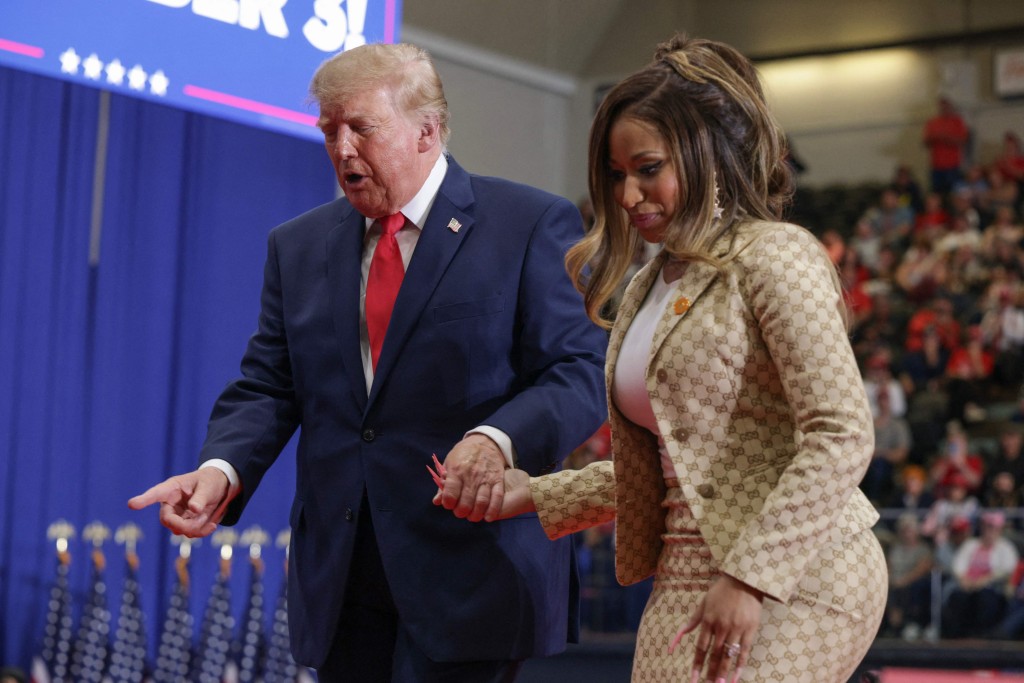 Singer Nikki Minaj walks with President Donald Trump during a campaign rally on October 25 in Port Huron, Michigan. AFP