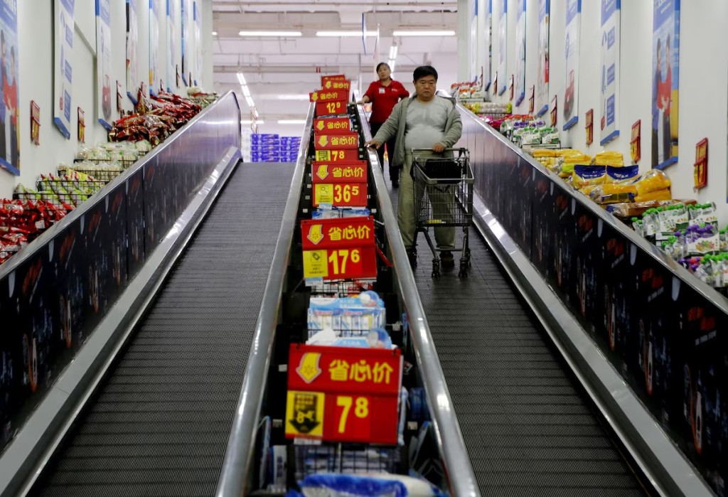 Shoppers ride on a travelator at a supermarket in Beijing, China, October 15, 2015. REUTERS