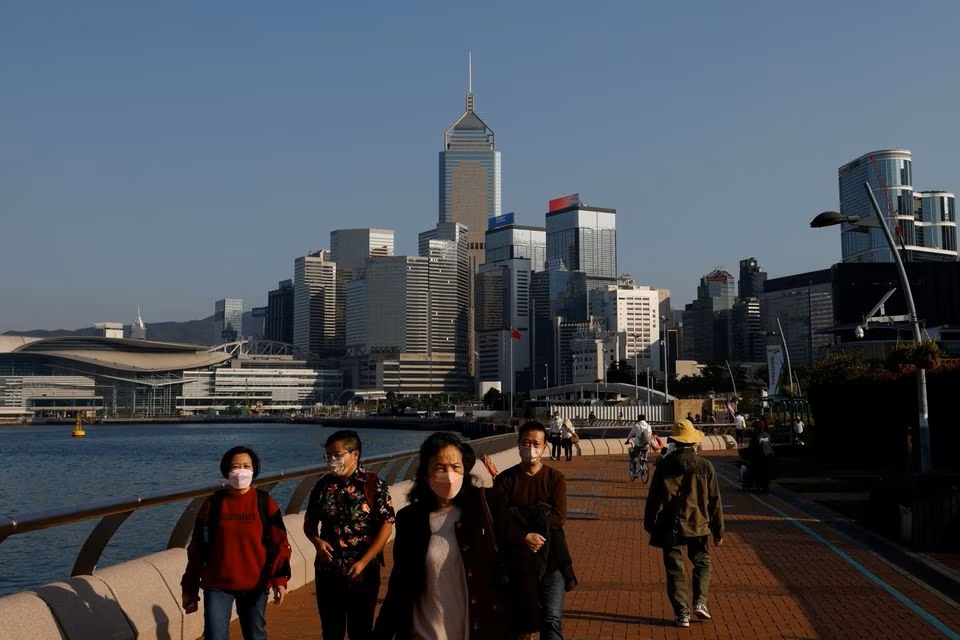 People wearing face masks walk on the street in Hong Kong. (Reuters) People wearing face masks walk on the street in Hong Kong. (Reuters)