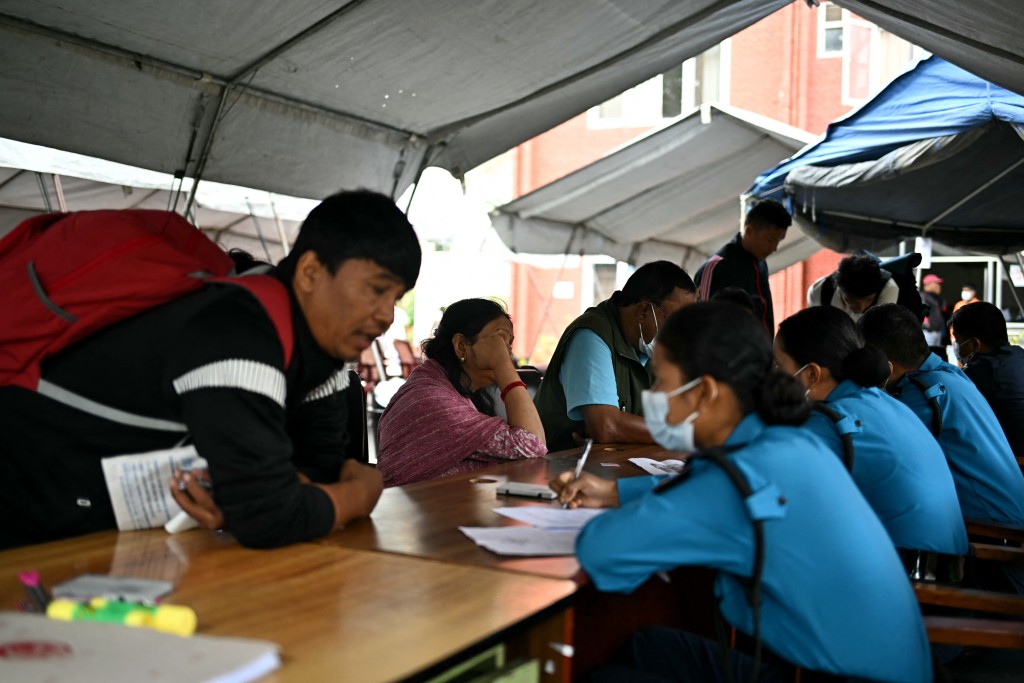 Photo by MANAN VATSYAYANA / AFP  Family members register their information with police personnel to give blood samples for DNA testing to help identify their missing relatives after flash floods, at the Nepal Police Hospital in Kathmandu on September 3, 2026.
