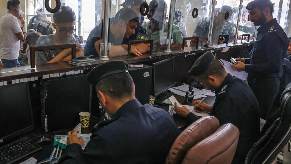 Civilians leaving Gaza display their documents as dual national Palestinians and foreigners prepare to cross the Rafah border with Egypt. (AFP) Civilians leaving Gaza display their documents as dual national Palestinians and foreigners prepare to cross the Rafah border with Egypt. (AFP)