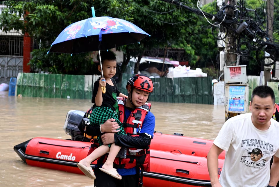 A rescue worker holds a child while evacuating residents by boat amid flooding caused by heavy rainfall from Typhoon Saudel in Minhou county, Fuzhou, Fujian province, China September 3, 2026. cnsphoto via REUTERS 