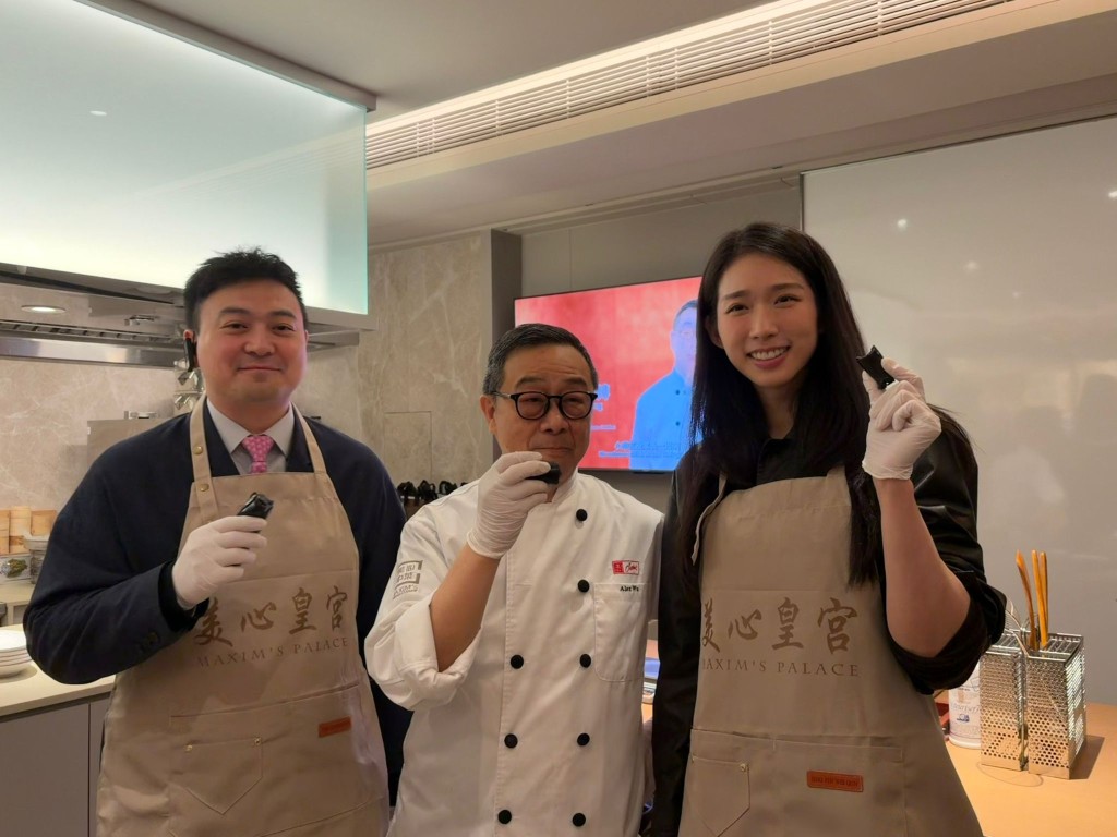 Lawmakers Jonathan Leung Chun (left) and Vivian Kong Man-wai (right) made black sesame rolls under the guidance of a chef
