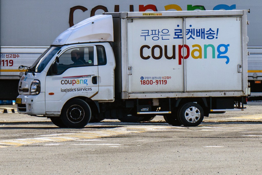 Photo by ANTHONY WALLACE / AFP A worker drives a delivery truck of South Korean e-commerce giant Coupang in Seoul on December 9, 2025.