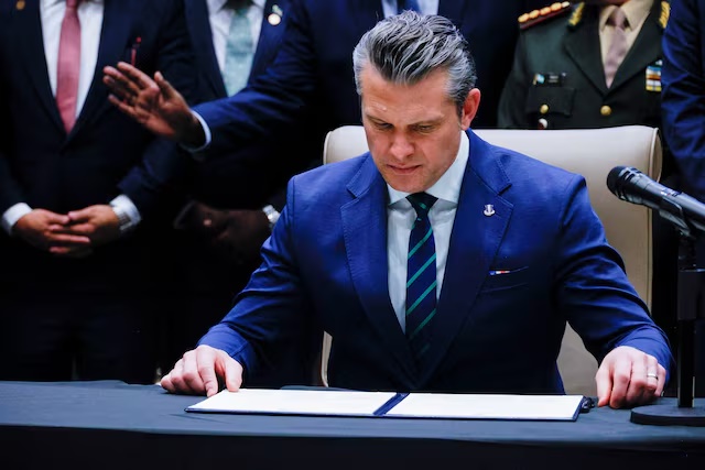 U.S. Secretary of Defense Pete Hegseth looks at the signed joint security agreement at the inaugural Americas Counter Cartel Conference with regional defense and security leaders at U.S. Southern Command headquarters in Doral, Florida, U.S., March 5, 2026. REUTERS/Maria Alejandra Cardona