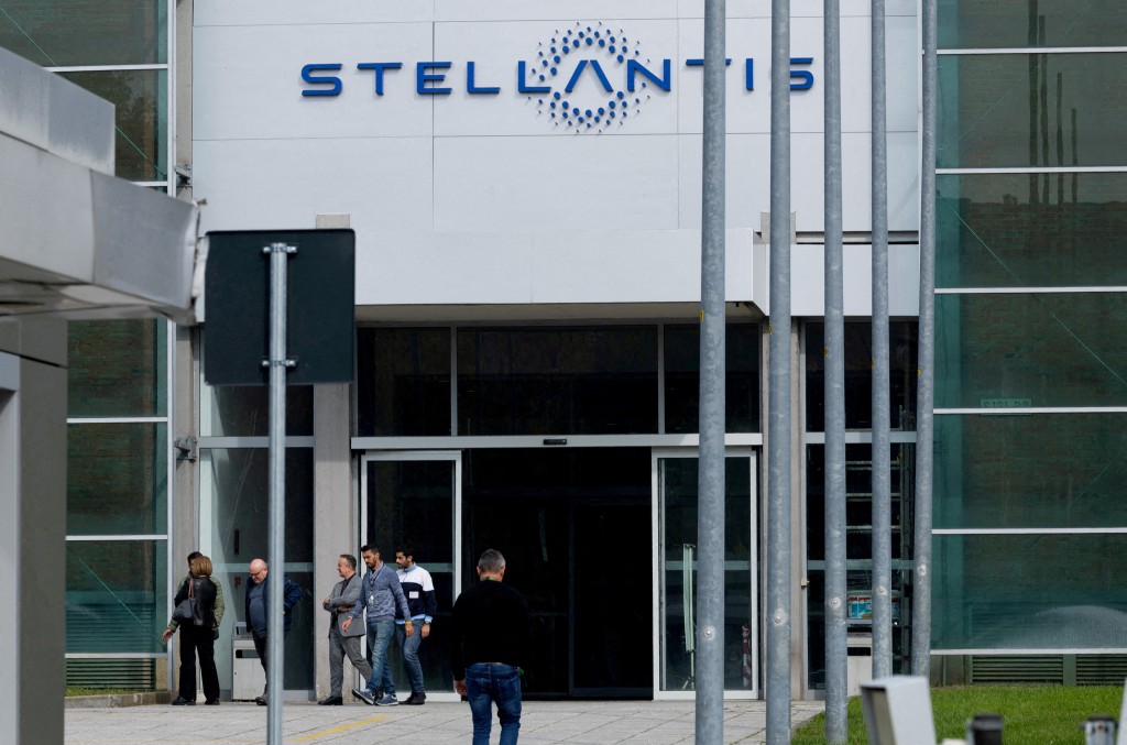 People walk next to the N.13 gate of the Franco-Italian automaker Stellantis factory of Mirafiori, in Turin, Italy October 15, 2024. REUTERS/Remo Casilli/File Photo