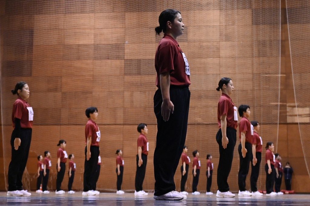 Photo by GREG BAKER / AFP  Students of Nippon Sports Science University rehearse for their annual synchronised walking performance, known as Shudankodo, in Yokohama on November 26, 2025.