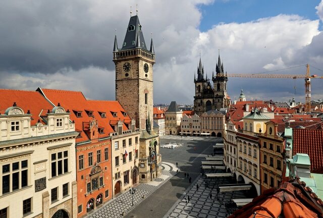 A clock showing the time at noon is pictured on a building, next to almost empty streets at Old Town Square  in Prague, Czech Republic, March 31, 2020. REUTERS/David W Cerny 