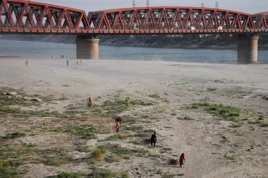 People walk on the dry riverbed of the Indus River in Hyderabad, Pakistan April 24, 2025. REUTERS/Yasir Rajput/File Photo