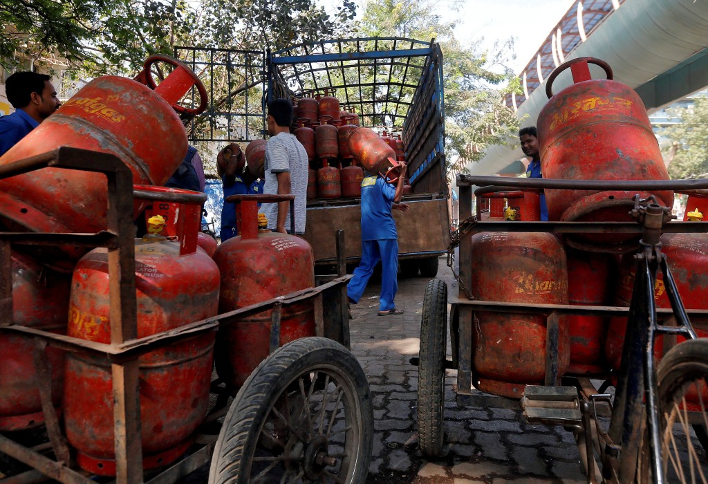 Workers load liquefied petroleum gas (LPG) cooking cylinders onto a supply truck outside a distribution centre in Mumbai, India, February 19, 2015.   REUTERS/Shailesh Andrade/File Photo