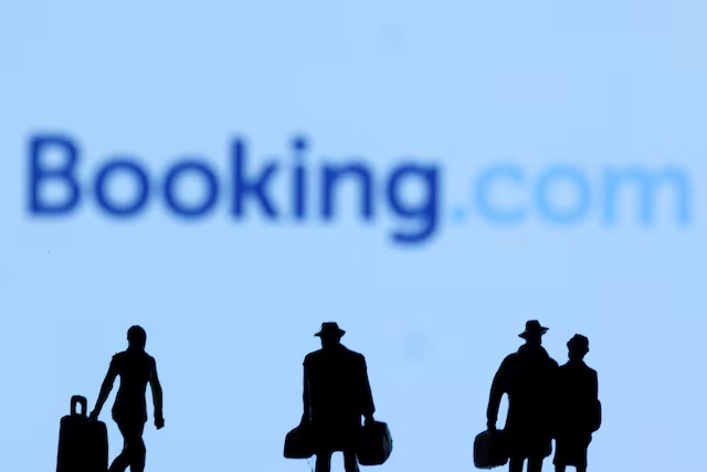 Figurines are seen in front of the Booking.com logo in this illustration taken, February 27, 2022. REUTERS/Dado Ruvic/Illustration
