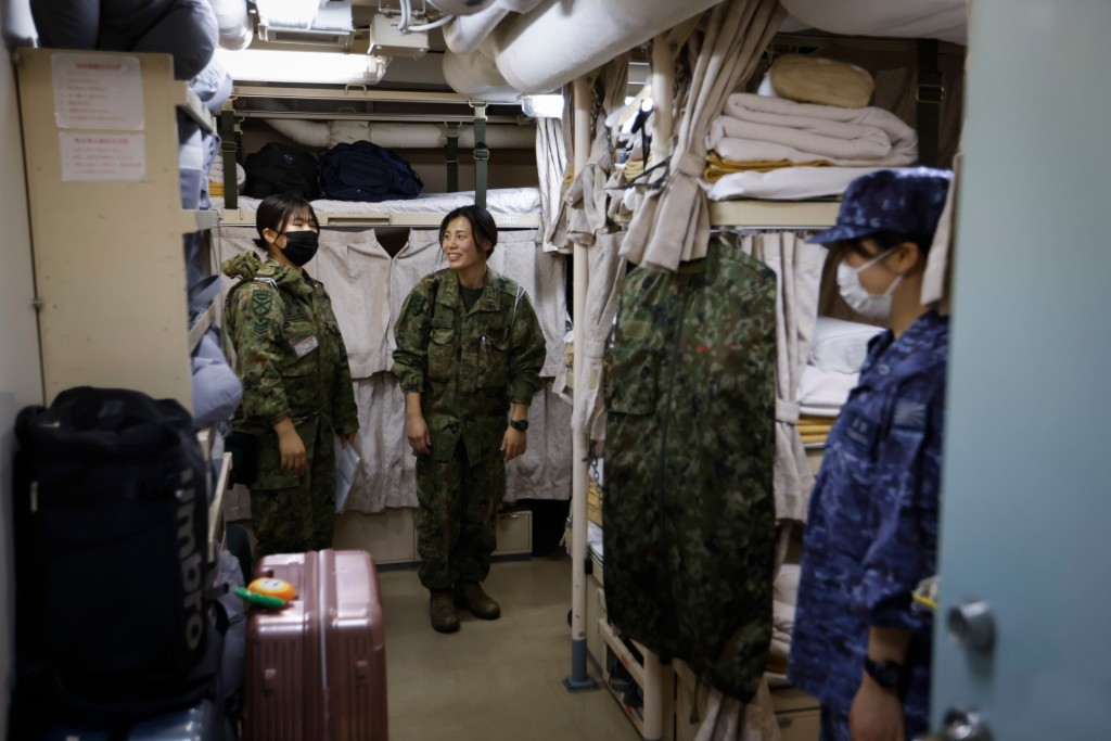 Hikari Maruyama (center) and Runa Kurosawa (left) stand in the women-only quarters during their break time inside the amphibious transport ship JS Osumi (LST-4001) in waters close to Okinawa, Japan November 14, 2023. REUTERS/Issei Kato