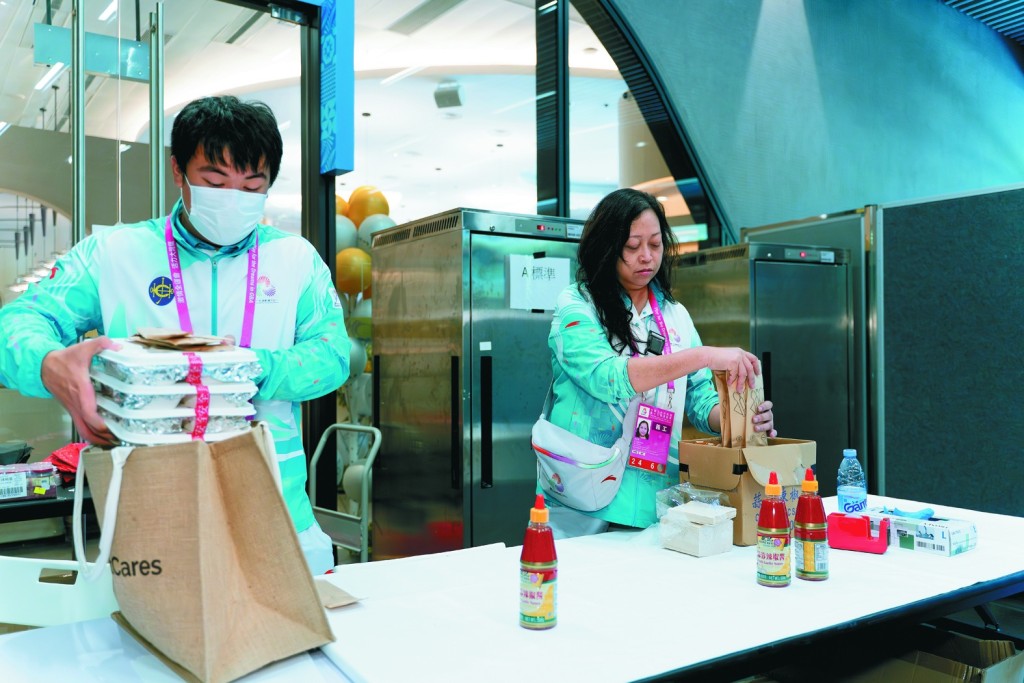 Volunteers packed meals for the technical officials at the competition venue.