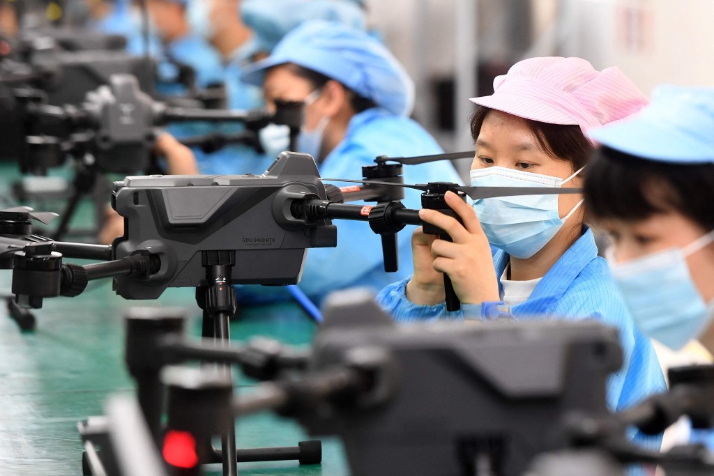 This photo taken on April 13, 2023 shows workers producing drones at a factory in Wuhan, in China's central Hubei province. (Photo by AFP)