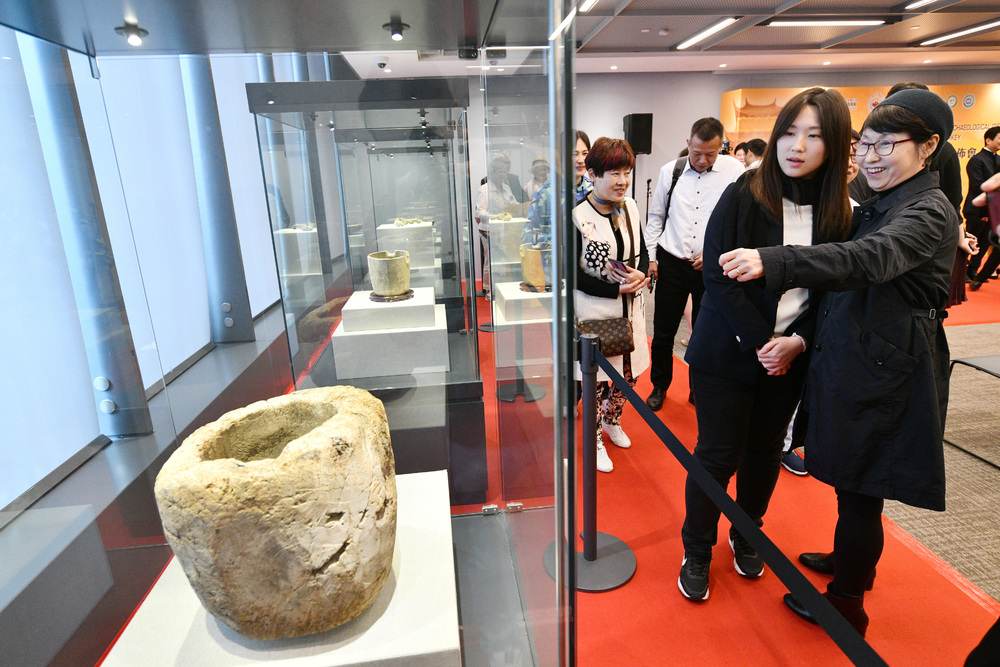Mortise-and-tenon joints found on Mount Ararat, top left and second left. Artifacts also collected from the mountain include those resembling a container, plate, rope and cup, which Andrew Yuen is seen viewing.