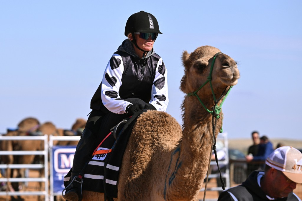 Photo by WILLIAM WEST / AFP  A photo taken on June 27, 2026 shows jockey Joanne Bell preparing at the start in her first camel race meet at the Marree Australasian Camel Cup in the South Australian outback town of Marree.