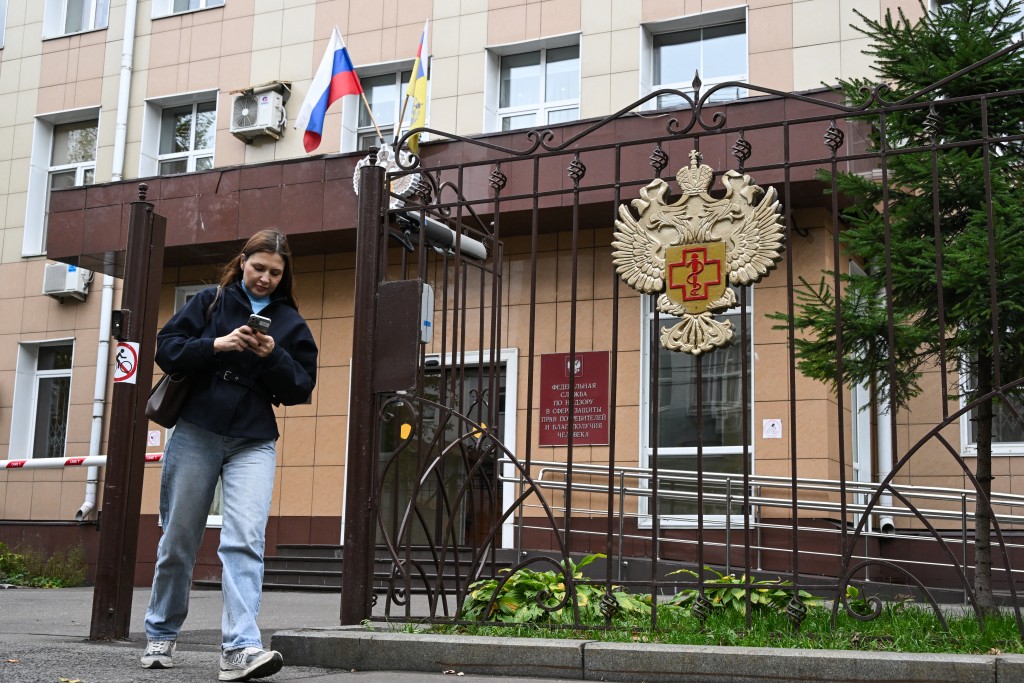 A woman leaves the grounds of the headquarters of Russia's consumer and health watchdog Rospotrebnadzor in Moscow on October 5, 2026. (AFP)