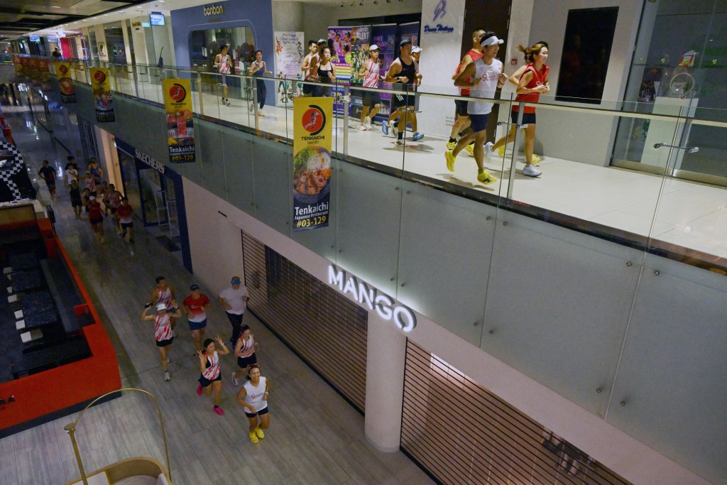 Photo by ROSLAN RAHMAN / AFP  Fitness enthusiasts run inside a mall due to haze situation outside in Singapore on October 24, 2026.