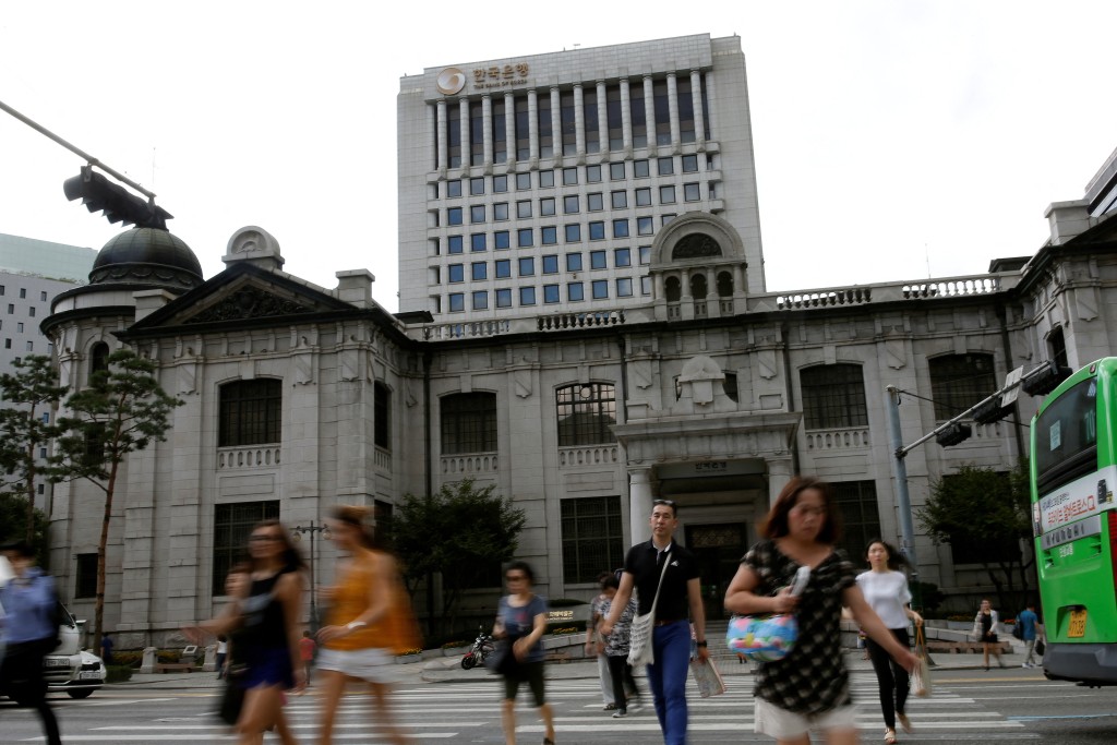 People walk on a zebra crossing in front of the buliding of Bank of Korea in Seoul, South Korea, July 14, 2016.  REUTERS