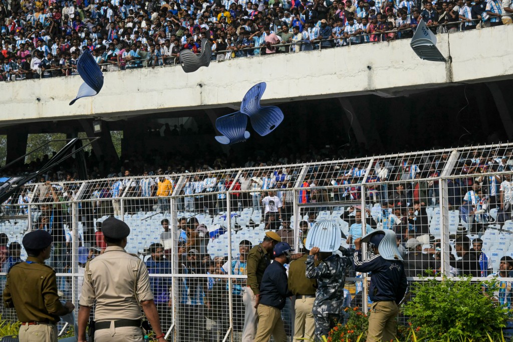 Photo by DIBYANGSHU SARKAR / AFP. Fans throw chairs as Inter Miami's Argentine forward #10 Lionel Messi departs from the Salt Lake Stadium in Kolkata on December 13, 2025.