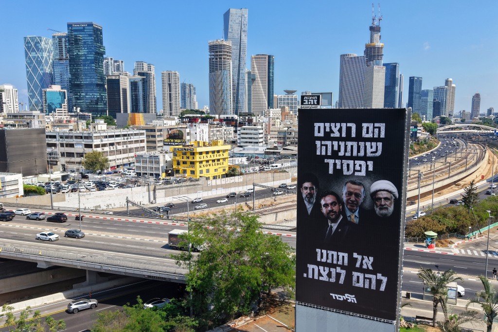 Photo by JACK GUEZ / AFP This photo shows an aerial view of an election campaign billboard by the Likud Party of Israel's Prime Minister Benjamin Netanyahu depicting (L-R) Iran's supreme leader Ayatollah Mojtaba Khamenei, New York City Mayor Zohran Mamdani, Turkey's President Recep Tayyip Erdogan, and Hezbollah Secretary-General Sheikh Naim Qassem, with Hebrew text reading "They want Netanyahu to lose," "Don't let them win," ahead of Israel's general election.
