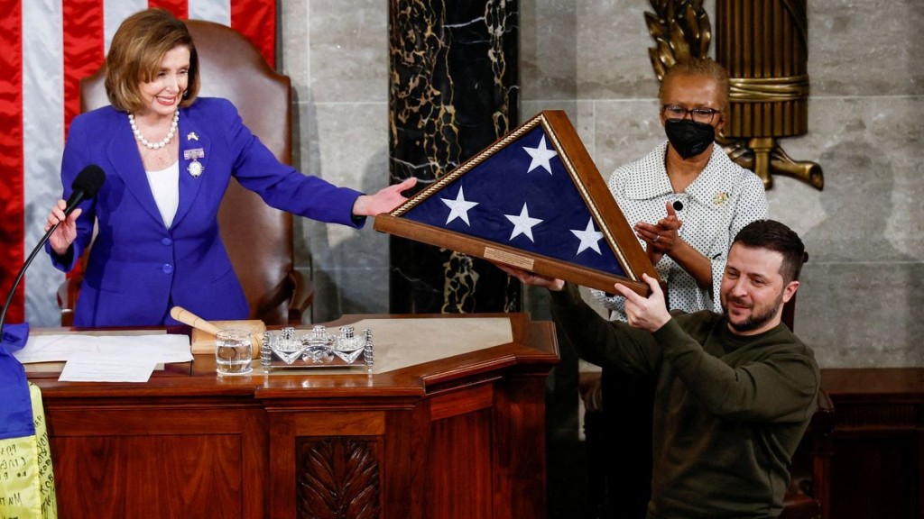 FILE PHOTO: Ukraine's President Volodymyr Zelensky receives a U.S. flag from U.S. House Speaker Nancy Pelosi during a joint meeting of the U.S. Congress in the House Chamber of the U.S. Capitol in Washington, U.S., December 21, 2022. REUTERS