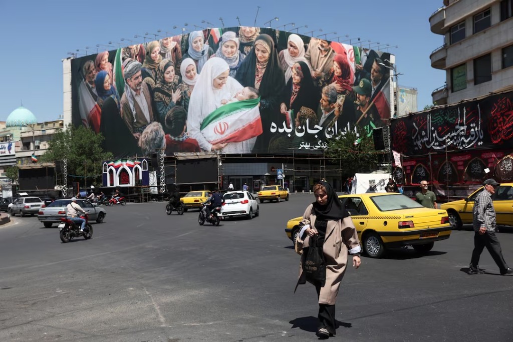  People walk past a billboard with a picture of Iranian people, in Tehran, Iran, May 25, 2026. Majid Asgaripour/WANA (West Asia News Agency) via REUTERS 