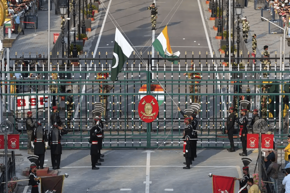 Pakistan’s Rangers soldiers, in black, and Indian Border Security Forces soldiers, behind the gate, lower their flags during a daily closing ceremony at the Wagah, a joint post on the Pakistan and India border, near Lahore, Pakistan, Monday, May 5, 2025. (AP Photo/K.M. Chaudary)