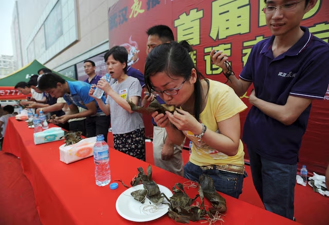Participants compete in a zongzi-eating competition held at a shopping mall in Wuhan, Hubei province to celebrate the Dragon Boat Festival. (Reuters)