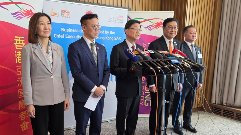 Chief Executive John Lee Ka-chiu (center) addressing the press in Kazakhstan on Tuesday.